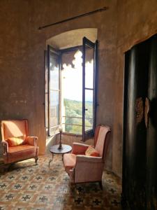 Zimmer mit 2 Stühlen, einem Tisch und einem Fenster in der Unterkunft Ca n'Heras in Canet de Adri