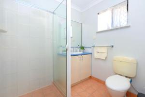a bathroom with a toilet and a glass shower at Beautiful Home stay in Townsville in Rosslea