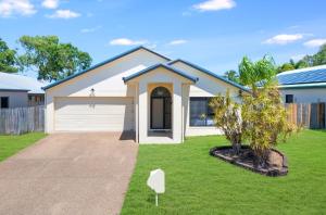 a house with a garage in a yard at Beautiful Home stay in Townsville in Rosslea