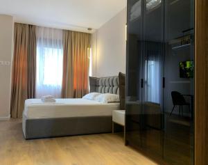 een slaapkamer met een groot bed en een raam bij Apartments Premium Center Tirana in Tirana