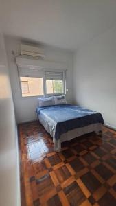 a bedroom with a bed and a window in it at 2 Dormitórios no Menino Deus ao lado do shopping Praia de Belas in Porto Alegre