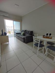 - un salon avec un canapé, une table et des chaises dans l'établissement Cobertura 302 vista mar Canasvieiras, à Florianópolis