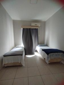 Cette chambre comprend 2 lits et une fenêtre. dans l'établissement Cobertura 302 vista mar Canasvieiras, à Florianópolis