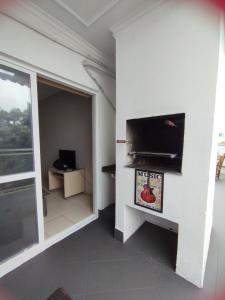 Cette chambre dispose d'un mur et d'une télévision à écran plat. dans l'établissement Cobertura 302 vista mar Canasvieiras, à Florianópolis