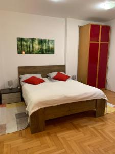 una camera da letto con un grande letto con cuscini rossi di Belvedere a Niš