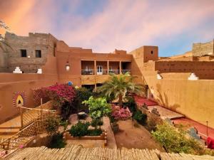 a building in the desert with a rainbow in the background at Riad Dar Zaouia in Zagora
