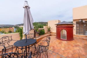 eine Terrasse mit Tisch und Sonnenschirm und einer Hundehütte in der Unterkunft San Miguel Actor's Studios in San Miguel de Allende