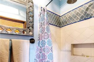 ein Bad mit einem Duschvorhang und einem Spiegel in der Unterkunft San Miguel Actor's Studios in San Miguel de Allende + 43 Fotos