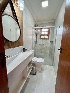 a bathroom with a sink and a toilet and a shower at Casa 2 Chalé Alto dos Bandeirantes-Tiradentes in Tiradentes