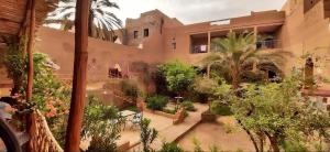 a courtyard of a building with trees and plants at Riad Dar Zaouia in Zagora