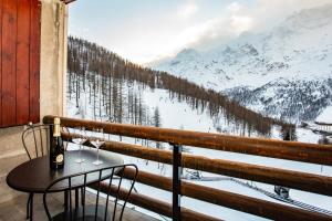 a table with two wine glasses on a balcony with a view at DEER LODGE in Breuil-Cervinia
