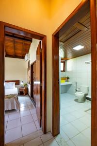 - une chambre avec un lit et une salle de bains avec des toilettes dans l'établissement Village em Taipu Fora - Apartamento pé na areia, à Marau