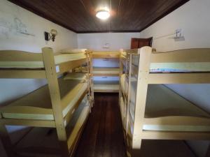 a room with three bunk beds in a room at Hostel Praia Brava in Arraial do Cabo