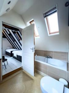 La salle de bains est pourvue d'une baignoire, d'un lit et de toilettes. dans l'établissement Fisherman's Cottage - Surf Retreat, à Wijk aan Zee