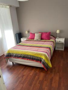 マル・デル・プラタにあるHermoso departamento a la calle a 300 mts del marのベッドルーム1室(大型ベッド1台、赤い枕付)