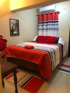 Un dormitorio con una cama con almohadas rojas. en Hotel familiar Doña Nida, en Santa Cruz de Barahona