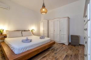 a bedroom with a large white bed with blue towels on it at BoHo by the Beach in Alghero