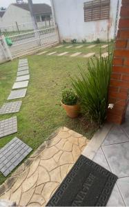 un patio con una casa de ladrillo y una planta en Casa de Itapocoróy Entre o parque Beto Carrero e o mar!, en Penha