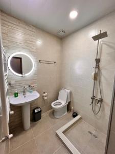 a bathroom with a toilet and a sink and a shower at Highland Kazbegi in Stepantsminda