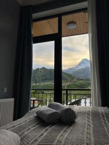a bedroom with a bed with a view of a mountain at Highland Kazbegi in Stepantsminda