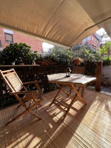 una mesa de madera y sillas en un patio en Acquedotti apartment with garden, en Roma
