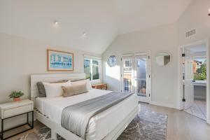 a white bedroom with a large bed and windows at Beautiful Beach Home - Ocean View, AC & Patio in San Diego