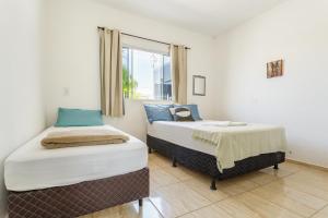 dwa łóżka w pokoju z oknem w obiekcie Moradas Palhoça w mieście Palhoça