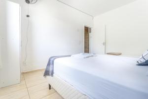 ein Schlafzimmer mit einem großen weißen Bett in einem Zimmer in der Unterkunft Moradas Palhoça in Palhoça