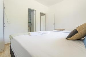 Moradas Palhoça في باليوسا: سرير أبيض في غرفة مع مرآة
