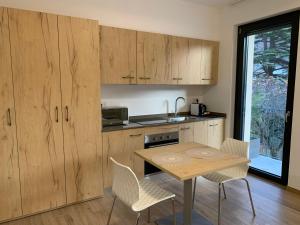 a kitchen with wooden cabinets and a table and chairs at Bernina Suite 2 - vicino al Bernina Express in Tirano