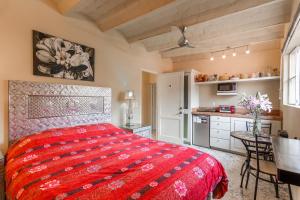 a bedroom with a red bed and a kitchen at Casas Artistas in San Miguel de Allende