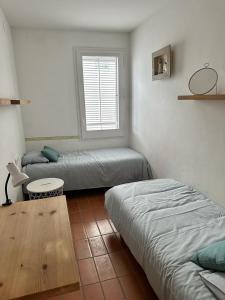 um quarto com duas camas e uma mesa e uma janela em RACO DE SES OLIVERES em Cadaqués
