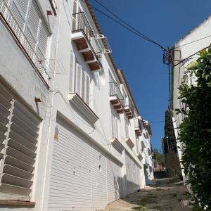 um edifício branco ao lado de uma rua em RACO DE SES OLIVERES em Cadaqués