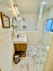 Baño blanco con lavabo y espejo en Lovely Cottage en Boise