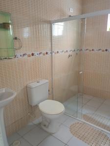 a bathroom with a toilet and a glass shower at Casa de Praia Tamandaré in Tamandaré