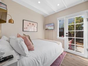 a bedroom with a white bed and a window at Classic Beach Bungalow - Parking, Private Patio & Pet Friendly! in San Diego