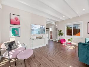 uma sala de estar com cadeiras cor-de-rosa e um sofá azul em Classic Beach Bungalow - Parking, Private Patio & Pet Friendly! em San Diego