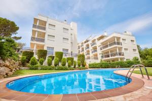 a swimming pool in front of a building at Paraíso en Cala Llobeta in L'Ametlla de Mar