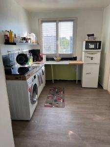 uma cozinha com um fogão e uma máquina de lavar roupa em Appartement avec un séjour balcon très lumineux em Orléans