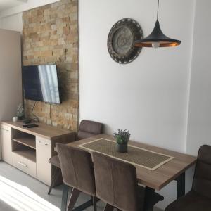 Un comedor con mesa y sillas y un televisor. en Apartman “N 17”Milmari-Kopaonik, en Kopaonik