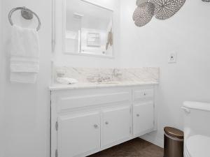 a white bathroom with a sink and a mirror at Sunset Cliffs Lookout - Ocean Front Luxury Condo in San Diego +20 photos