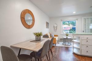 a dining room with a table and chairs and a mirror at Seaside Serenity 1-BR Apt with peek-a-boo sound views in Seattle