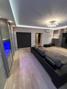ein großes Wohnzimmer mit Sofa und TV in der Unterkunft Apartment on Arkhipenka with Panorama View in Lwiw