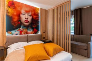 a bedroom with a painting of a woman with red hair at La Pergola Suites in Dossobuono