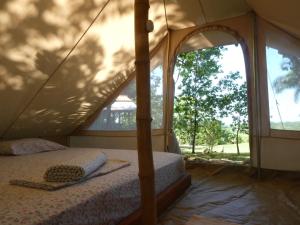 a bedroom with a canopy bed in a tent at Alouatta Playa Coyote in San Francisco