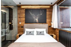 a bedroom with a bed with a deer head on the wall at DEER LODGE Mountain view apartment with ski-in access in Breuil-Cervinia