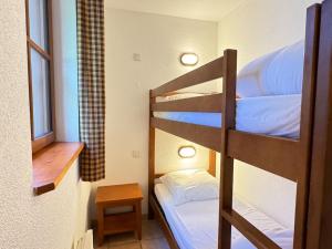 een kleine kamer met twee stapelbedden en een tafel bij Joli duplex pr 5p, parking, balcon, piscine été in Cauterets