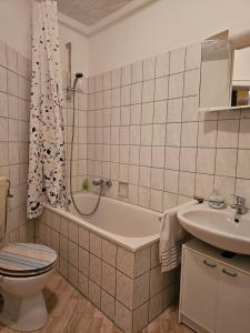 Un baño con inodoro, bañera y lavabo. en Eigener Eingang, 1-Zimmer mit Bett und große Wohnküche mit Schlafcouch, en Oberhausen