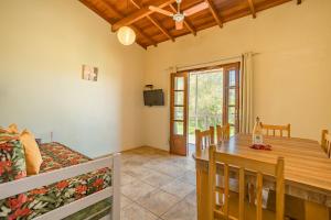 a dining room and living room with a wooden table at Pousada do Paraiso in Barra de Ibiraquera