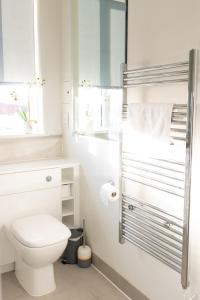 a white bathroom with a toilet and a mirror at Modern, comfy 2 bedroom flat in Hatfield town centre in Hatfield